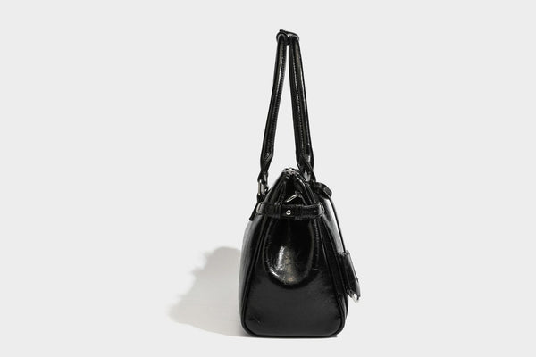 Structured glossy crinkled leather-look satchel with double top handles, front metal-plaque tab, silver-tone hardware, and