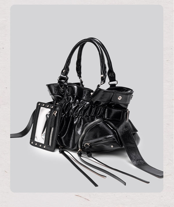 Black glossy ruched convertible tote bag with silver-tone rivets, detachable wide shoulder strap, external zip pouch, and