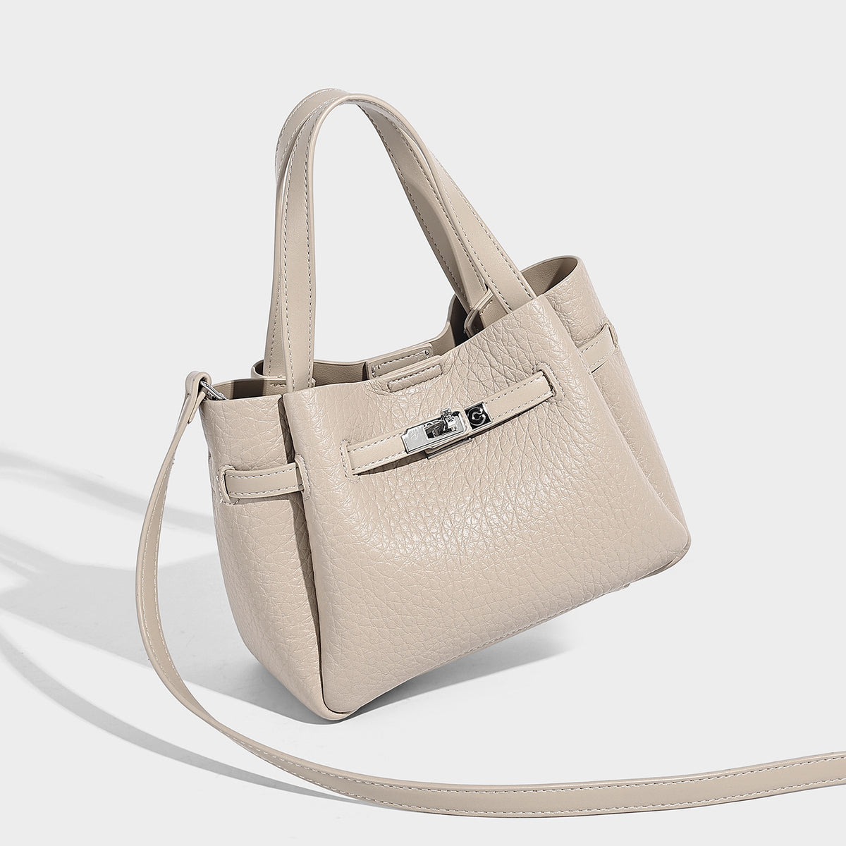 Small structured pebbled bucket tote with double top handles, silver turn-lock hardware, and detachable shoulder strap
