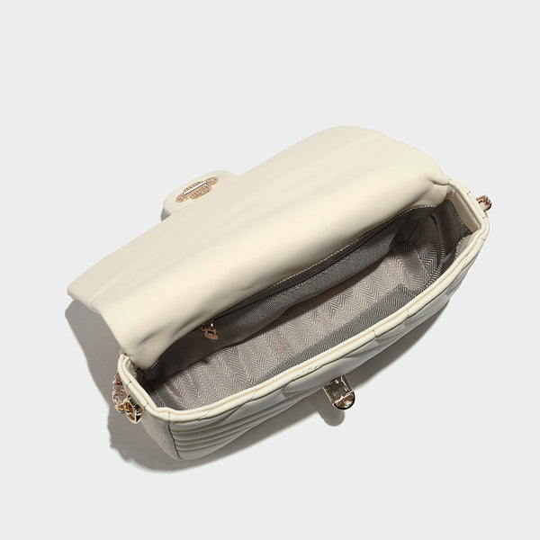Compact cream quilted flap crossbody bag with wave stitching, gold-tone chain strap, and four-petal turn-lock clasp, detail