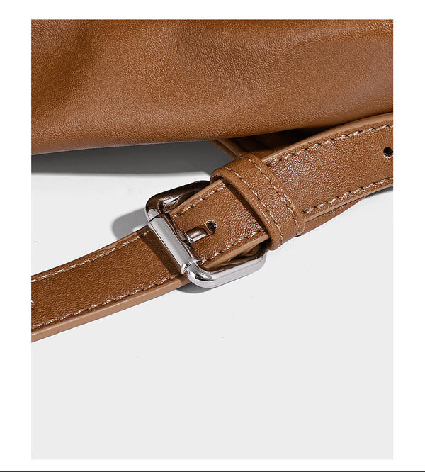 Structured tan leather-look flap backpack handbag with top handle, silver buckle hardware, and fold-over front closure
