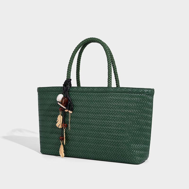 Structured woven-texture tote bag with brown braided top handles, decorative tassel charm, and detachable shoulder strap