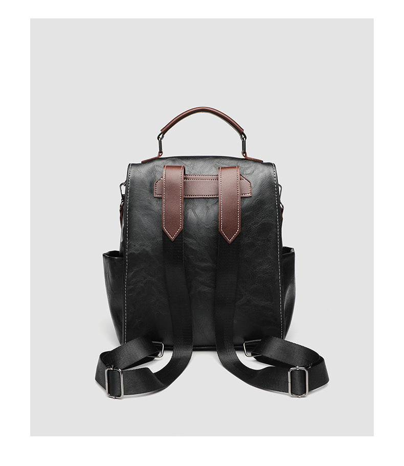 Structured black leather-look convertible backpack handbag with brown contrast trim, buckle front pocket, double-zip top