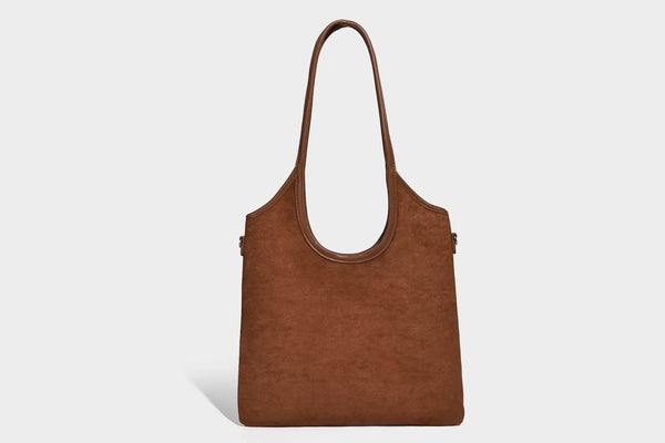 Tote-Bag in warmem Braun mit matter Wildlederoptik, langen Tragegriffen, geprägtem Logo, silberfarbenen Beschlägen und passendem, Detail