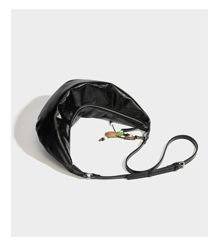 Lässig fallende Hobo-Schultertasche in Halbmondform mit glänzender, geknautschter Lederoptik, schmalem Riemen, silberfarbenen Ringbeschlägen und