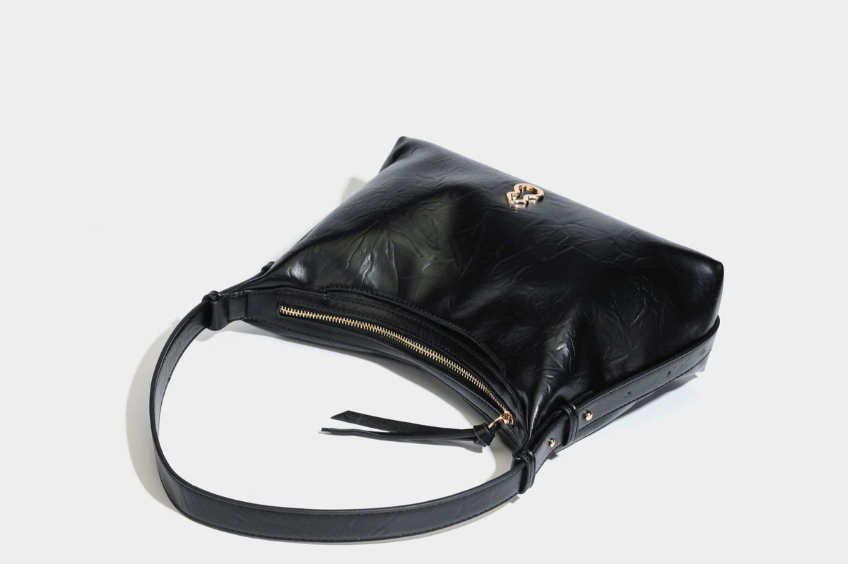 Übergroße, lässig fallende Hobo-Schultertasche aus glänzendem, geknittertem Lederimitat mit goldfarbenem Reißverschluss und Emblem-Beschlägen, Detailansicht