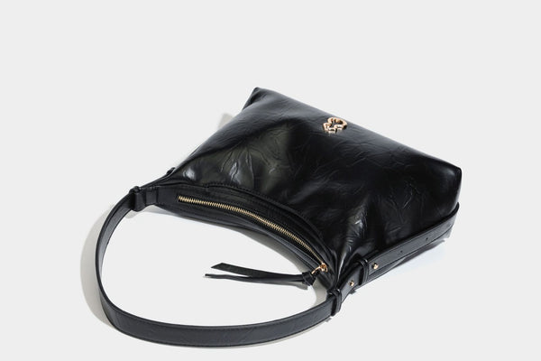 Übergroße, lässig fallende Hobo-Schultertasche aus glänzendem, geknittertem Lederimitat mit goldfarbenem Reißverschluss und Emblem-Beschlägen, Detailansicht