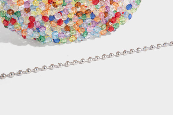Kleine, abgerundete Hobo-Bag mit facettierten, durchscheinenden Perlen in Kristalloptik, passendem Perlenhenkel oben und silberfarbenen Details