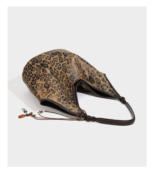 Large slouchy leopard-print shoulder tote bag with glossy tan-and-brown finish, dark brown leather-look trim, single