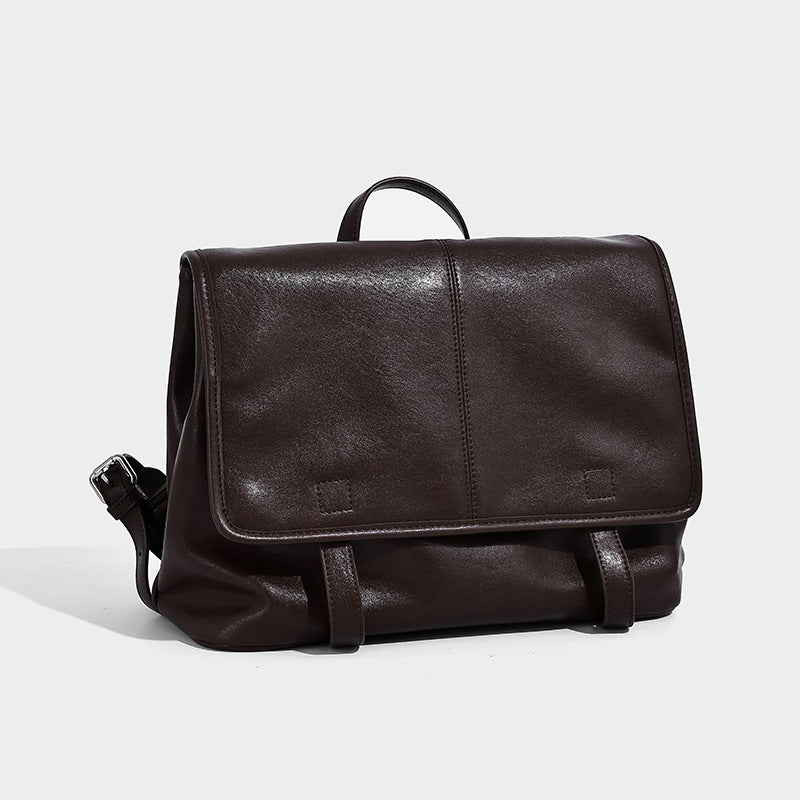 Structured tan leather-look flap backpack handbag with top handle, silver buckle hardware, and fold-over front closure