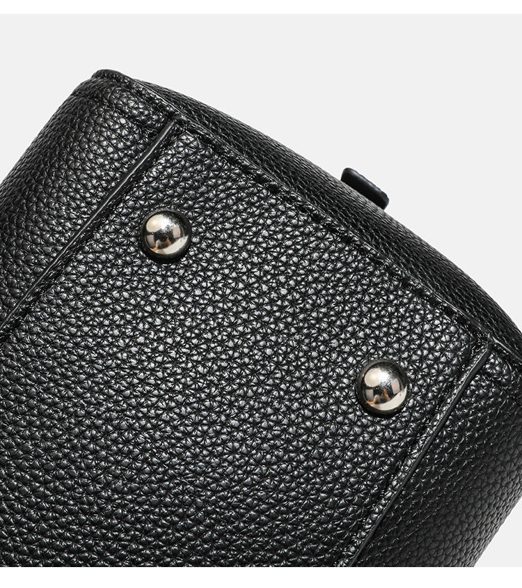 Structured pebbled leather-look top-zip barrel bag with dual handles, detachable shoulder strap, and attached croc-pattern