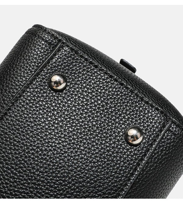 Structured pebbled leather-look top-zip barrel bag with dual handles, detachable shoulder strap, and attached croc-pattern