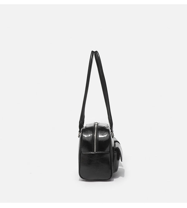 Structured glossy leather-look bowling shoulder bag with two front flap pockets, top zip closure, and long double shoulder