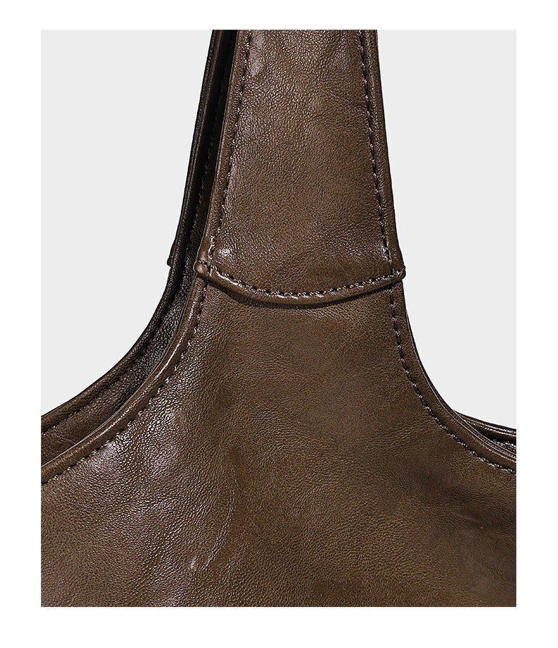 Large open-top tote bag with crinkled leather-look finish, long double shoulder straps, and embossed circular detail on