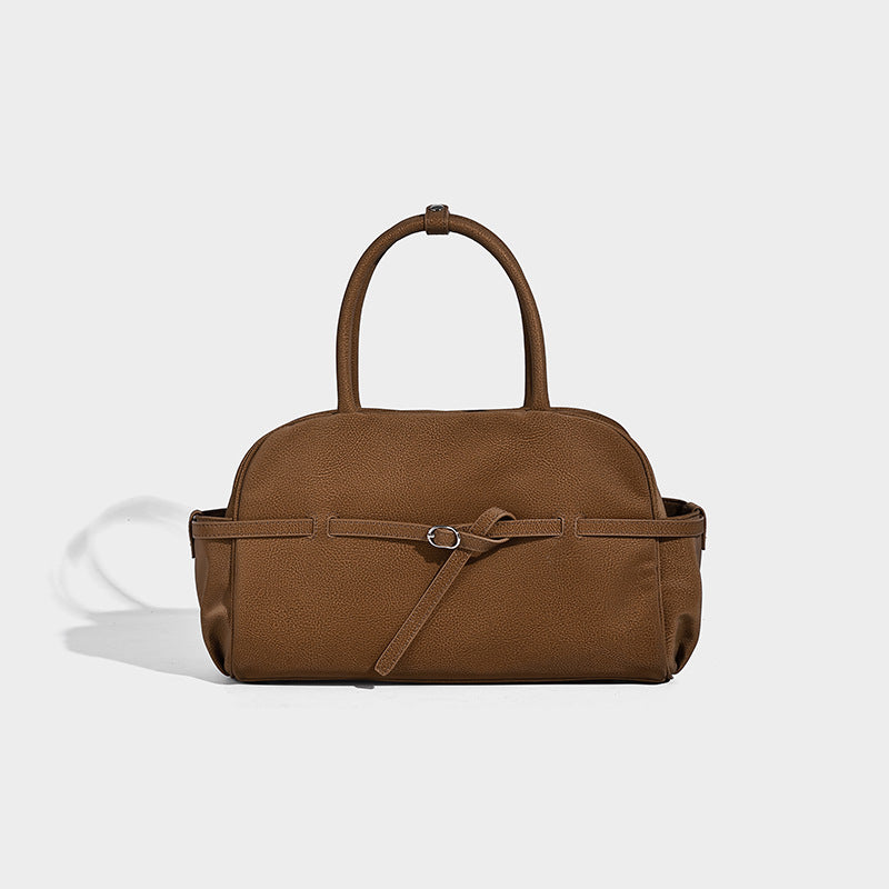 Strukturierte Henkeltasche mit matter, genarbter Oberfläche, umlaufendem Riemen mit Ringbeschlägen, zwei Tragegriffen und abnehmbarem Umhängeriemen