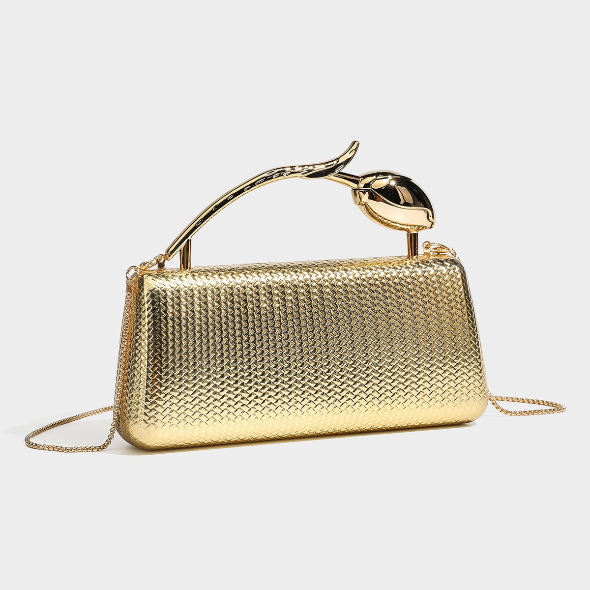 Structured rectangular metallic woven clutch bag with sculptural gold-tone leaf top handle and detachable chain strap, detail