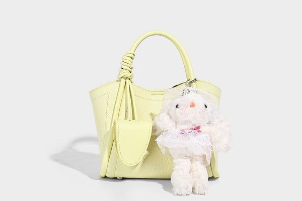 Structured mini tote bag in pebbled leather-look finish with knotted top handles, front flap pocket, and detachable shoulder