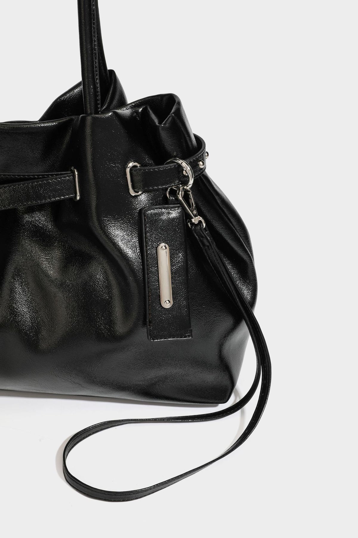 Glänzende schwarze, weich fallende Schultertasche mit gerafftem Abschluss, zwei langen Trageriemen, silberfarbenen Beschlägen und abnehmbarem Umhängeriemen