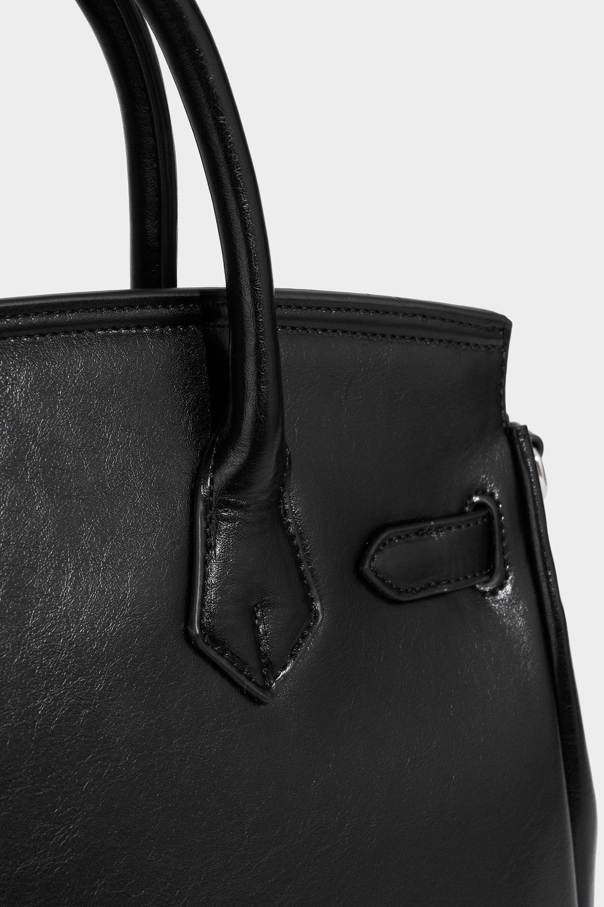 Structured black leather-look satchel bag with silver padlock hardware, front zip pockets, key charms, and top handles