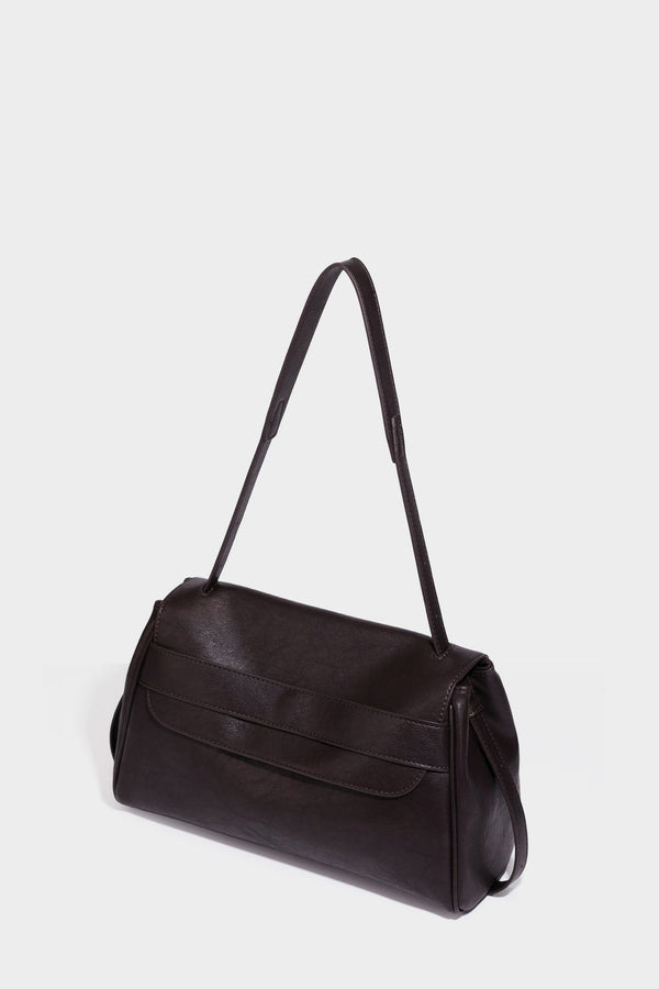 Strukturierte rechteckige dunkelbraune Schultertasche in Lederoptik mit Klappe, mehrlagigem Detail auf der Vorderseite und langem verstellbarem Riemen, Detailansicht