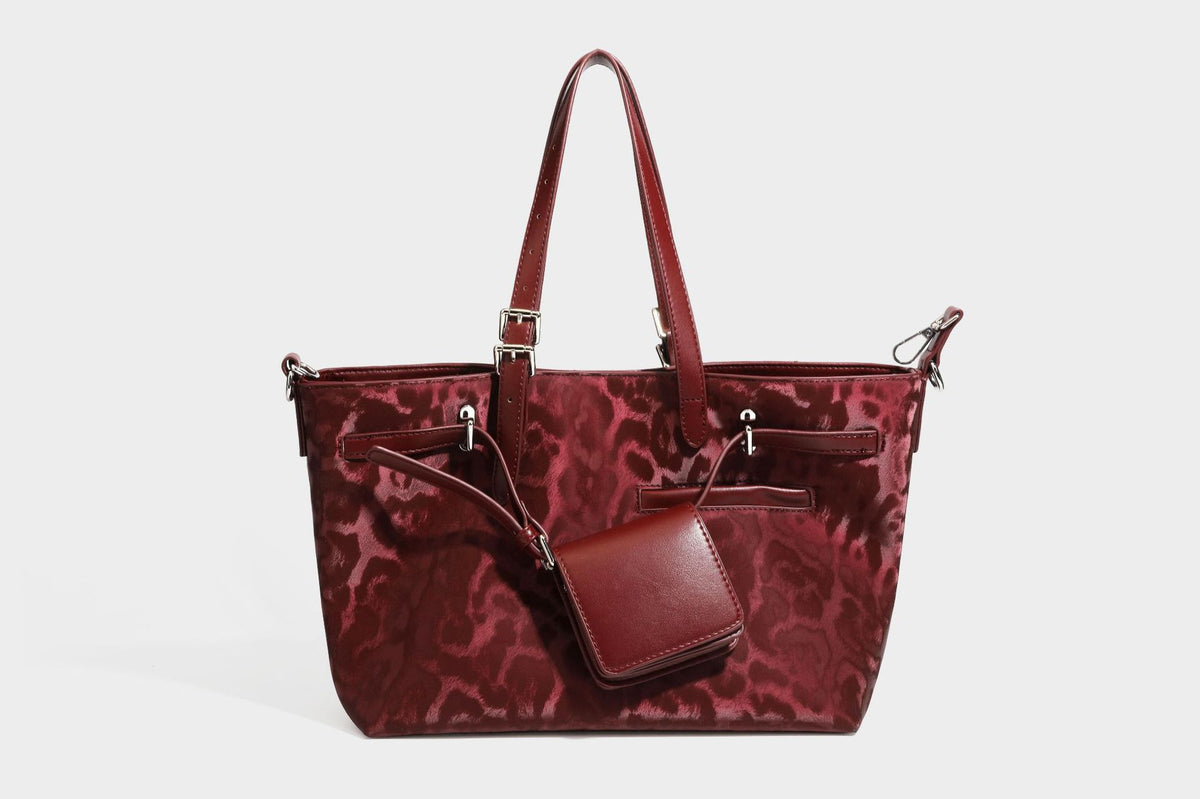 Glossy leopard-print tote bag with leather-look dark trim, dual top handles, detachable shoulder strap, and attached front