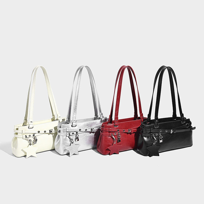 Structured glossy leather-look shoulder bag with wraparound belt straps, silver-tone hardware, and dangling star charm