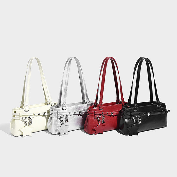 Structured glossy leather-look shoulder bag with wraparound belt straps, silver-tone hardware, and dangling star charm