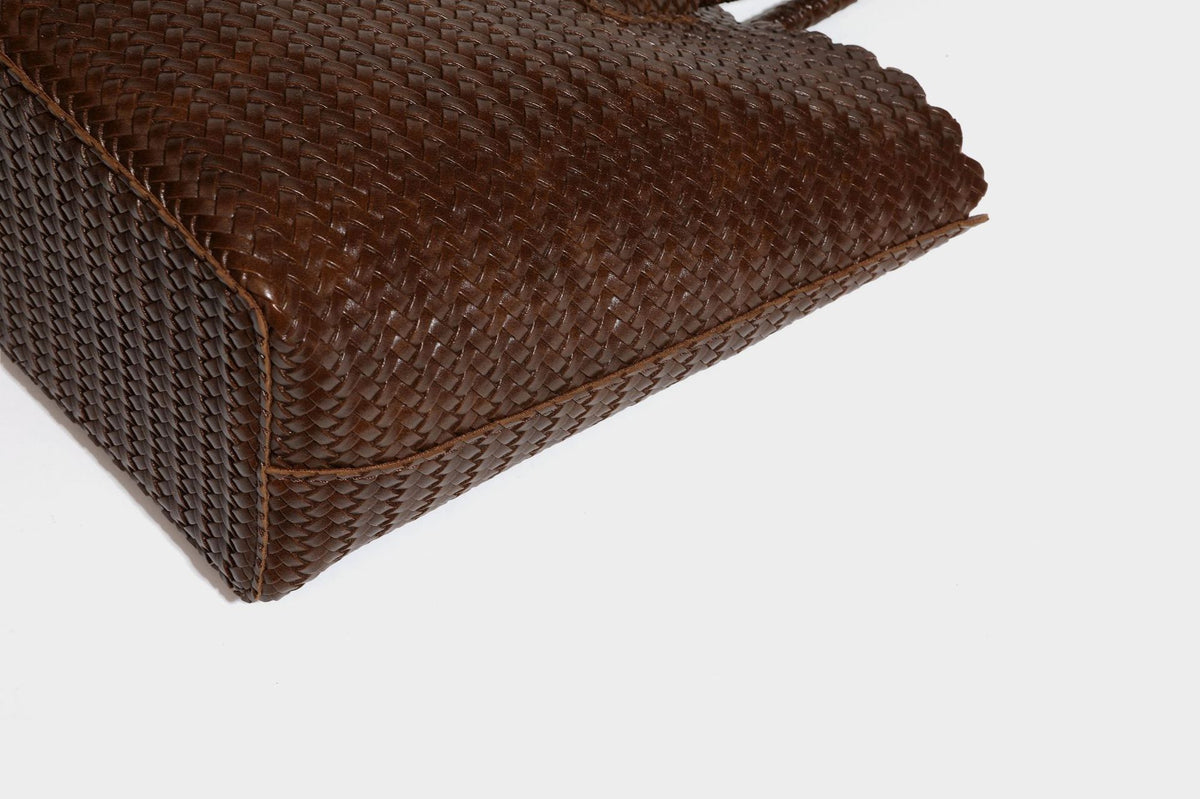 Large open-top woven leather-look tote bag in dark brown with scalloped edge, braided double shoulder straps, and decorative
