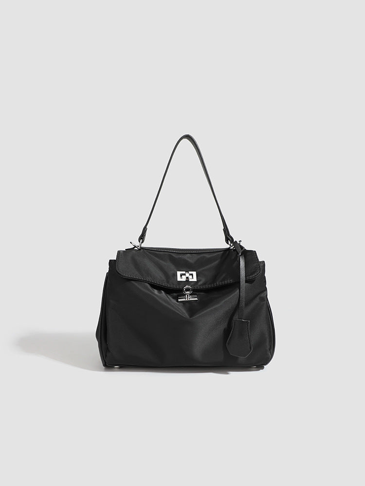 Structured black leather-look flap satchel bag with silver turn-lock hardware and top handle, detail view 10