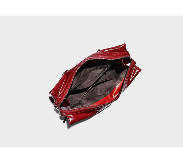 Structured rectangular glossy tote shoulder bag with belt buckle front strap and dangling charm hardware, detail view 11