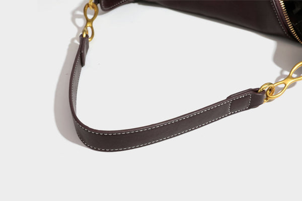 Lässige halbmondförmige Hobo-Schultertasche in Dunkelbraun mit goldfarbenem Ring und Kettenglied-Beschlägen sowie Reißverschluss oben, Detailansicht
