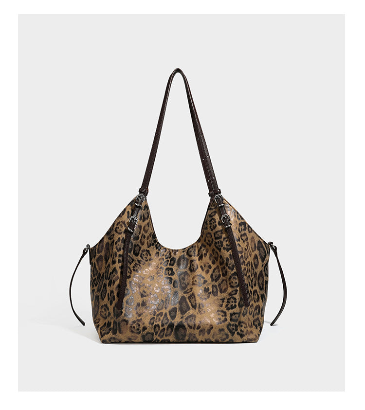 Slouchy leopard-print shoulder tote bag in tan and brown with long double straps, side tie straps, and dangling charm, detail