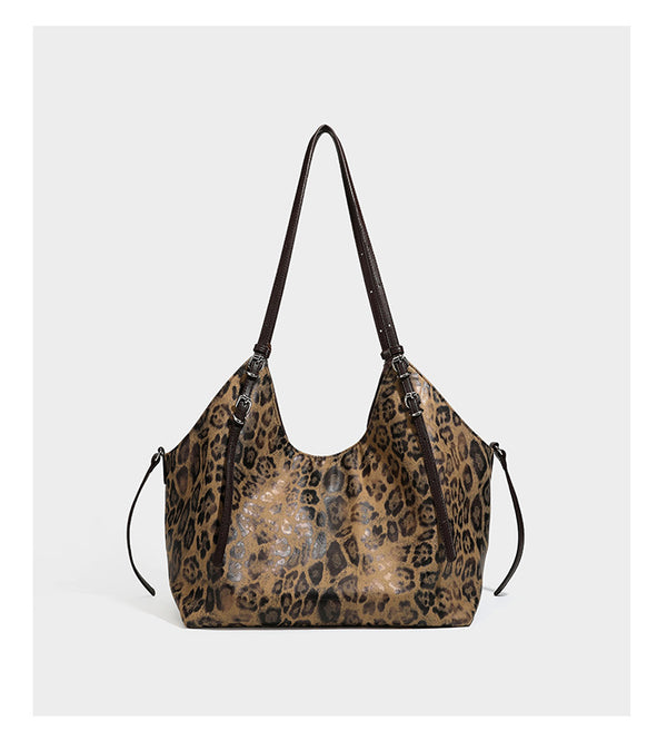 Slouchy leopard-print shoulder tote bag in tan and brown with long double straps, side tie straps, and dangling charm, detail
