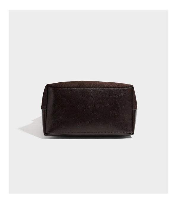 Dunkelbraune, lässig fallende Hobo-Schultertasche mit velourslederähnlich strukturierter Oberfläche, glatter lederähnlicher Paspelierung und Details in Antikgoldoptik, Detailansicht