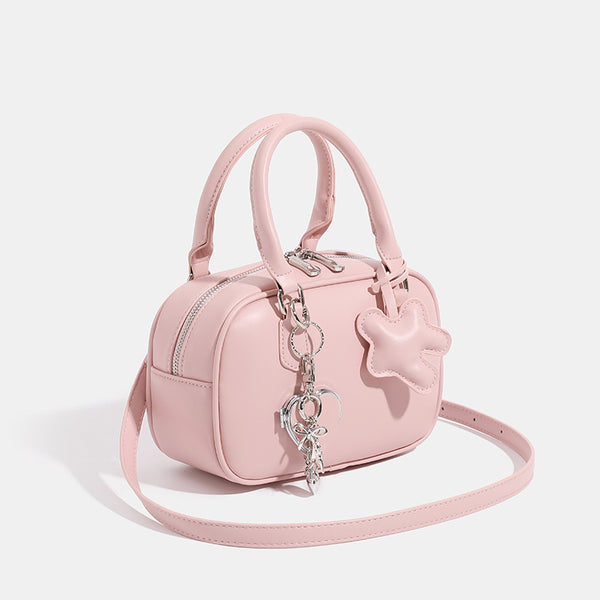 Small structured rounded-rectangle mini handbag with glossy leather-look finish, top zip closure, silver-tone hardware, and