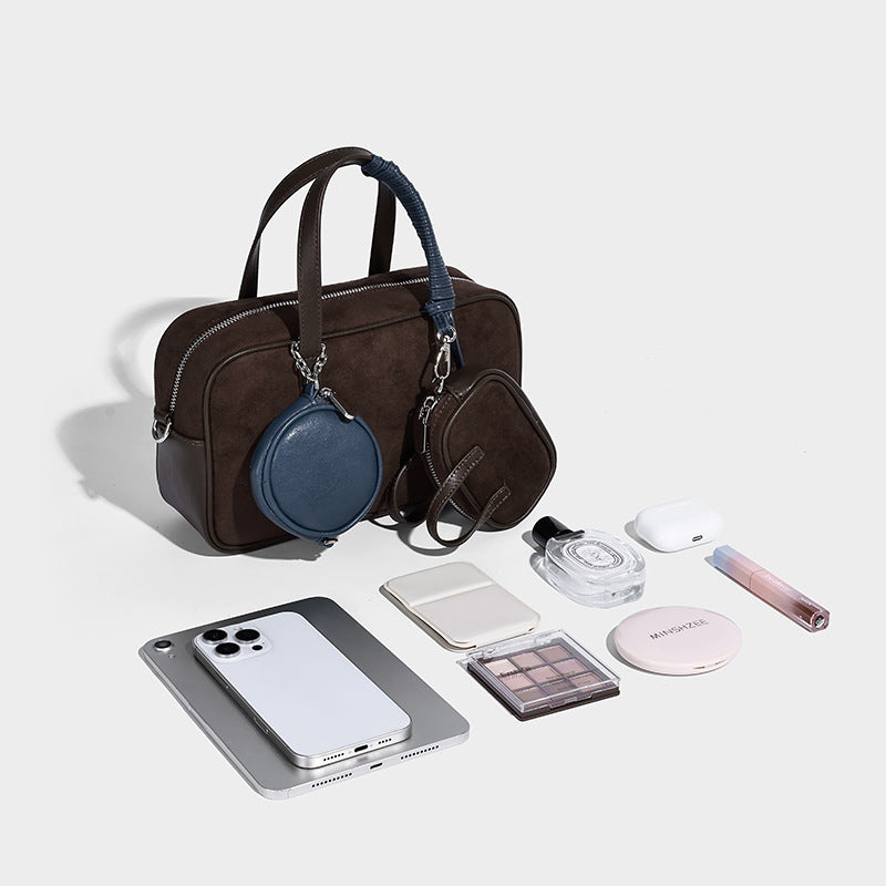 Strukturierte Boston-Tasche im Bowling-Stil in Veloursleder-Optik und Dunkelbraun mit Tragegriffen in Blau und abnehmbarer runder Mini-Tasche, Detailaufnahme