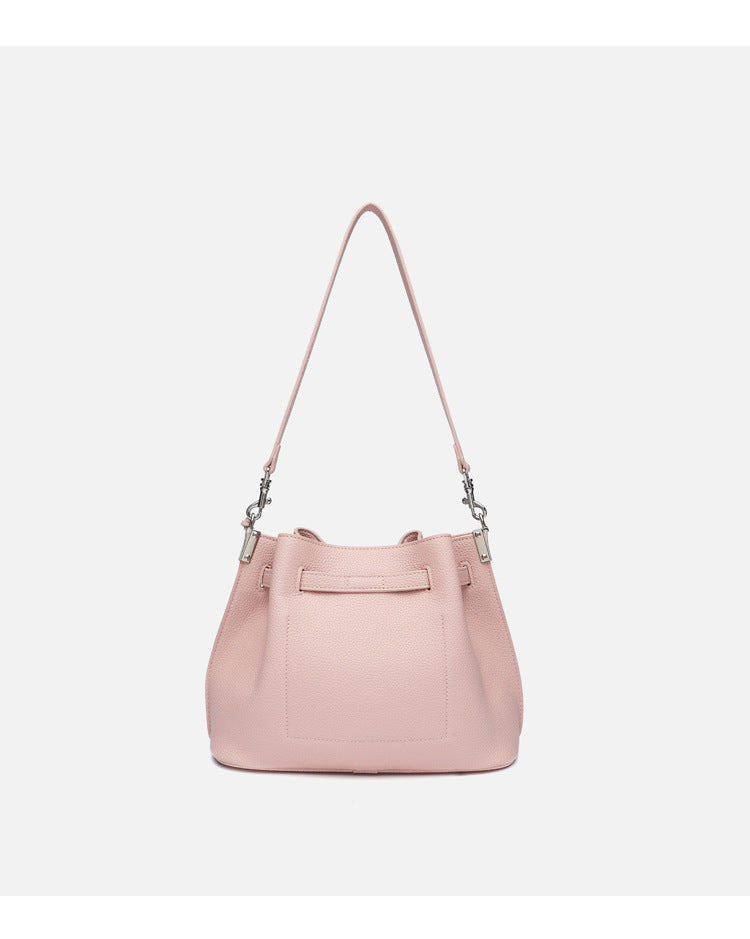 Soft-structured pebbled leather-look bucket bag with silver turn-lock front clasp and adjustable crossbody strap, detail view