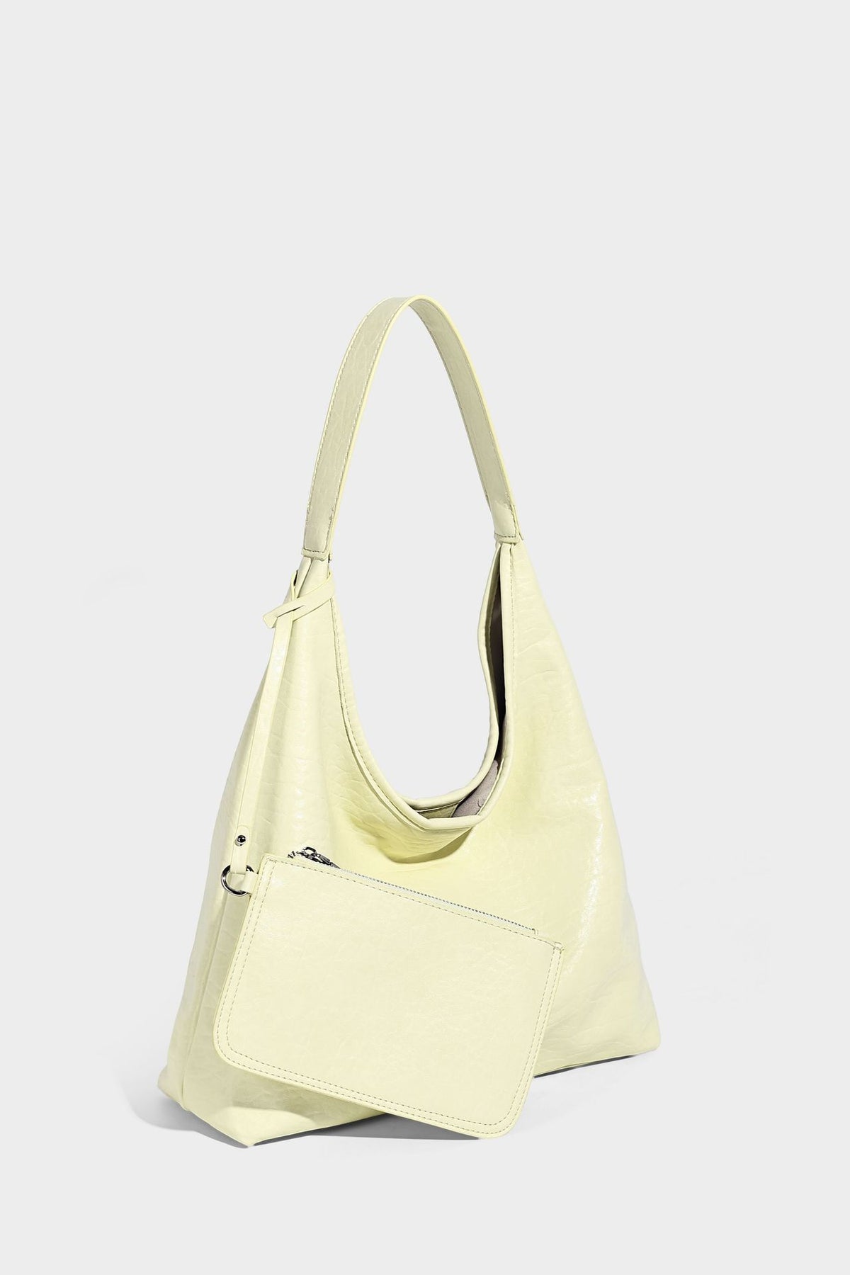 Slouchy hobo shoulder bag in pale yellow glossy pebbled leather-look finish with single shoulder strap and detachable front