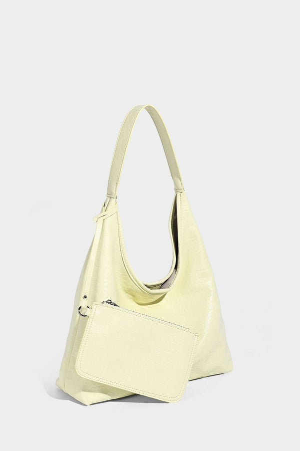 Slouchy hobo shoulder bag in pale yellow glossy pebbled leather-look finish with single shoulder strap and detachable front