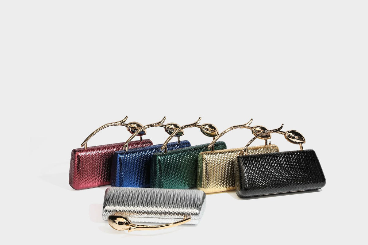 Structured rectangular metallic woven clutch bag with sculptural gold-tone leaf top handle and detachable chain strap, detail