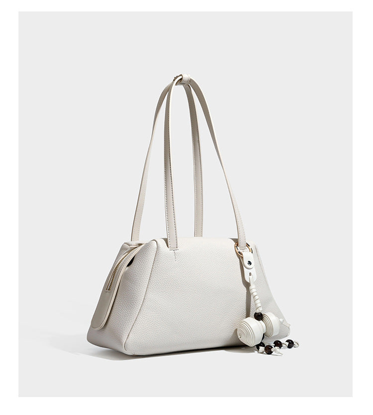 Structured trapezoid shoulder bag in dark brown pebbled leather-look finish with slim double straps, top zip closure, side