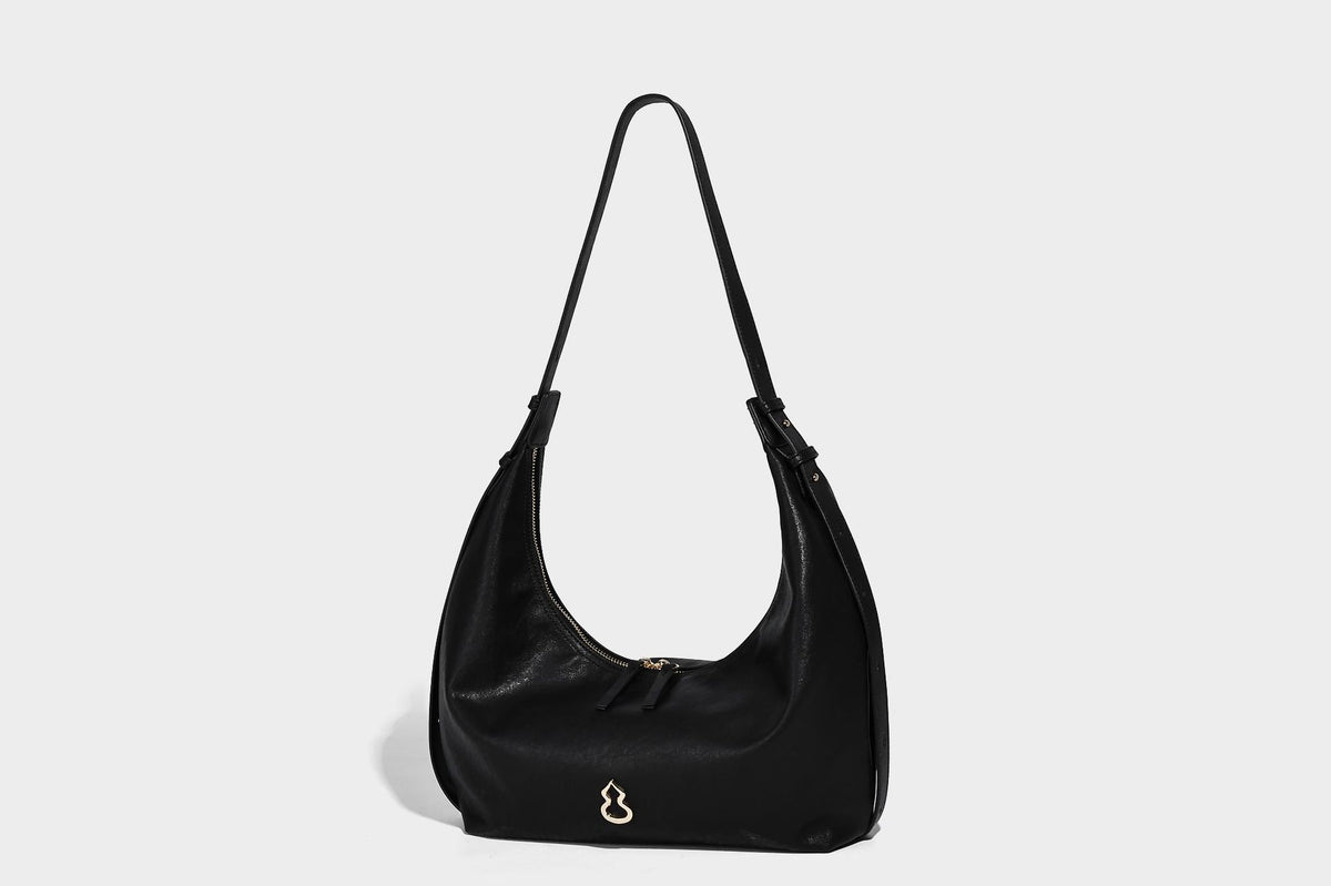 Lässig fallende, sichelförmige Hobo-Schultertasche in glatter dunkelbrauner Lederoptik mit Logo-Anhänger in Goldoptik und verstellbarem Schulterriemen