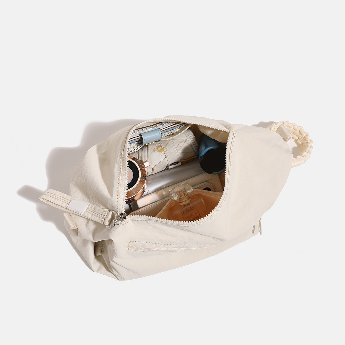 Lässige Crossbody-Bag aus weichem Stoff mit geflochtenem Kordel-Tragegriff, diagonalem Reißverschlussfach auf der Vorderseite und silberfarbenen Details, Detailansicht