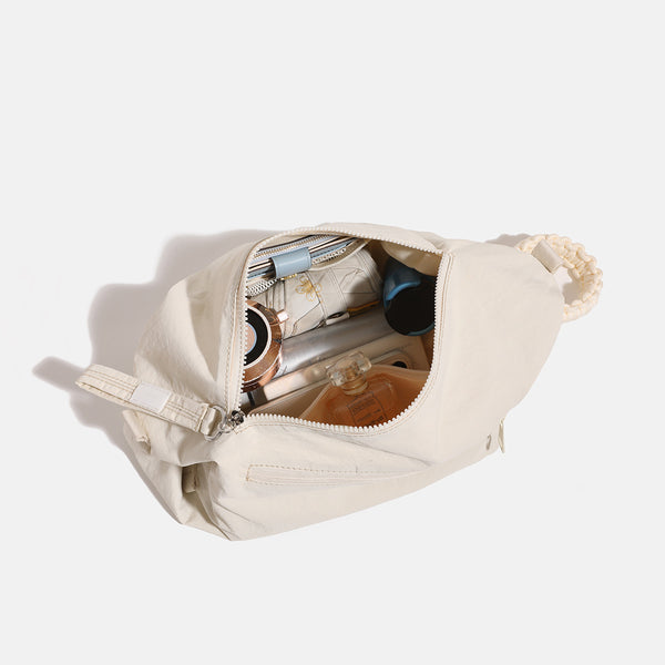 Lässige Crossbody-Bag aus weichem Stoff mit geflochtenem Kordel-Tragegriff, diagonalem Reißverschlussfach auf der Vorderseite und silberfarbenen Details, Detailansicht