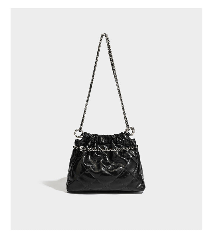 Glossy diamond-quilted drawstring bucket bag with silver chain shoulder strap and medallion charm, detail view 12