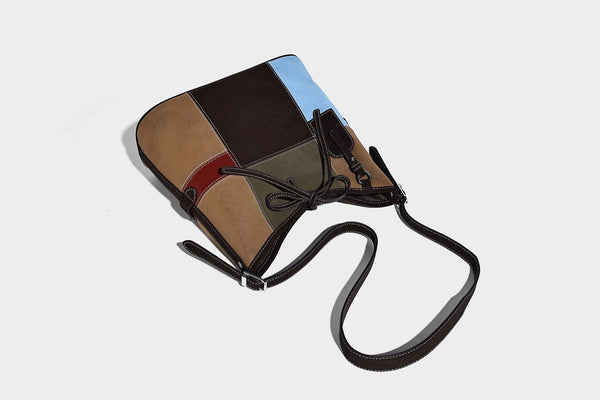 Patchwork bucket tote shoulder bag with tan, dark brown, olive, red, and sky blue color-block panels, white contrast, detail