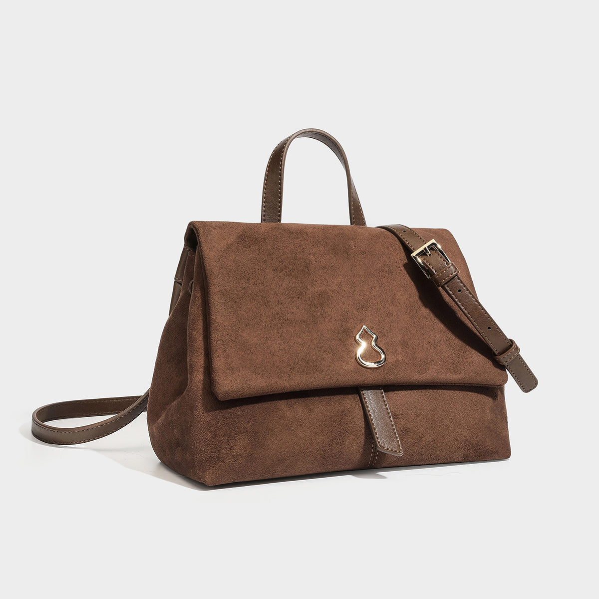 Structured matte suede-finish flap satchel bag with gold-tone emblem hardware, short top handle, and adjustable crossbody