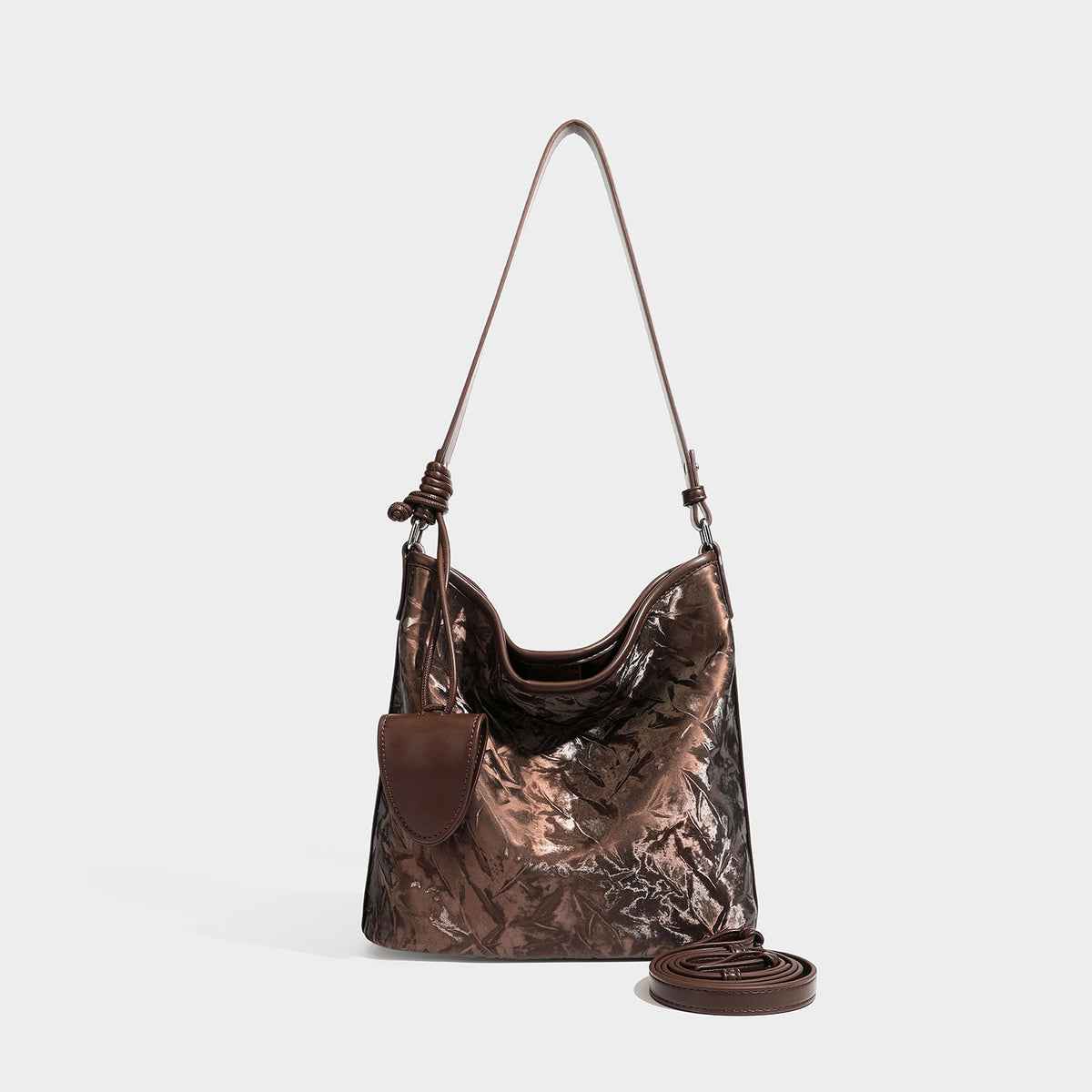 Große Hobo-Schultertasche mit Knitterglanz in tiefem Braun, schmalem verstellbarem Riemen, geknoteten Beschlägen und angesetztem seitlichem Überschlag