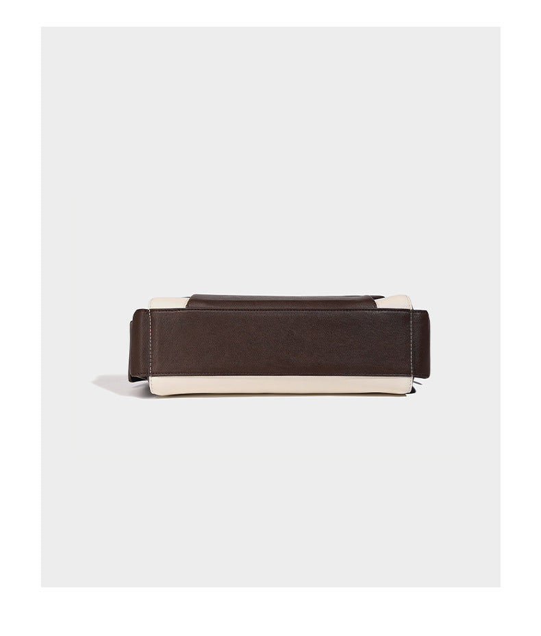 Structured flap crossbody bag in dark brown and cream color-block with white contrast stitching, adjustable shoulder strap