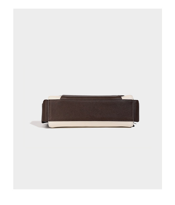 Structured flap crossbody bag in dark brown and cream color-block with white contrast stitching, adjustable shoulder strap